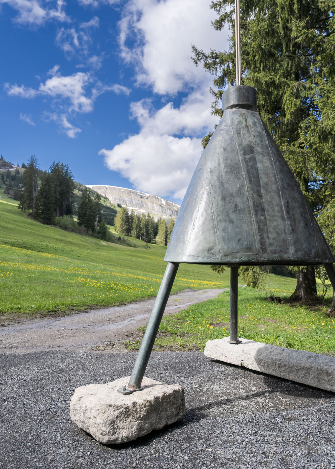 Die Klangskulptur besteht aus einem grossen, umgekehrten Metalltrichter mit zwei unterschiedlich hohen und gewichteten Antennen