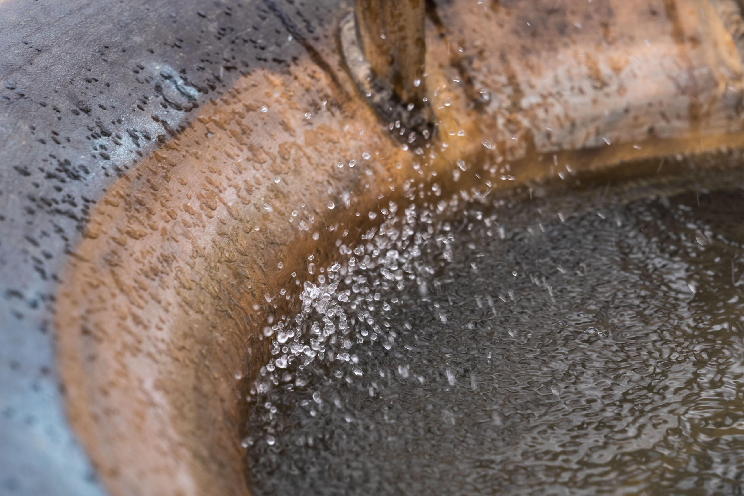 Das sprudelnde Wasser der Skulptur Hüpfwasser im Metallbecken