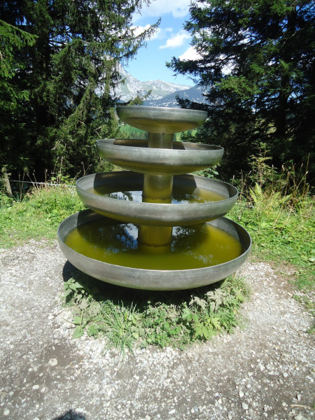 Die Skulptur Klangschalenbaum besteht aus vier übereinanderliegenden, unterschiedlich grossen Klangschalen welche mit Wasser gefüllt sind