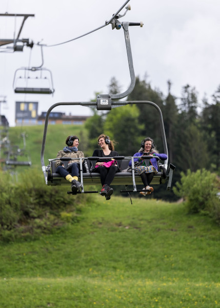 Soundride mit dem Sesselilift der Toggenburger Bergbahnen mit drei lachenden und lauschenden Besuchern