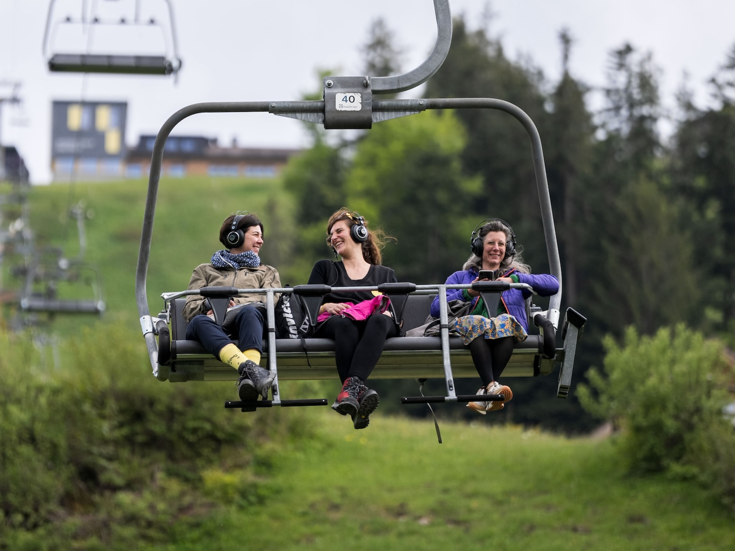 Soundride mit dem Sesselilift der Toggenburger Bergbahnen mit drei lachenden und lauschenden Besuchern
