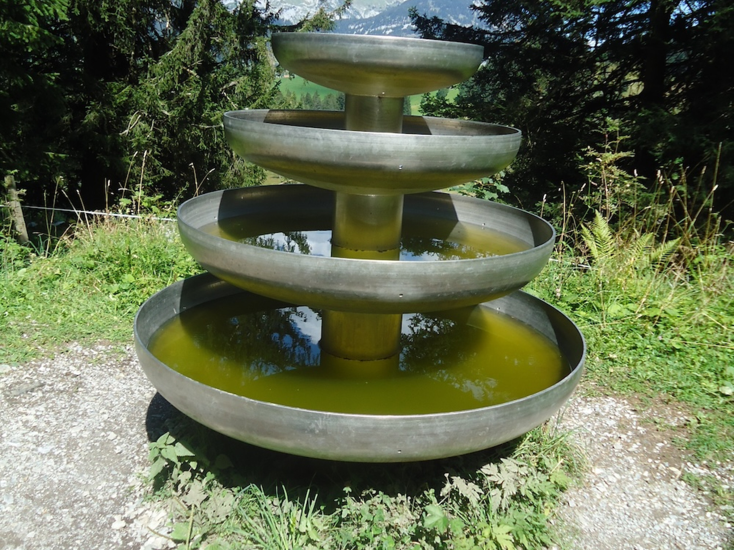 Die Skulptur Klangschalenbaum besteht aus vier übereinanderliegenden, unterschiedlich grossen Klangschalen welche mit Wasser gefüllt sind