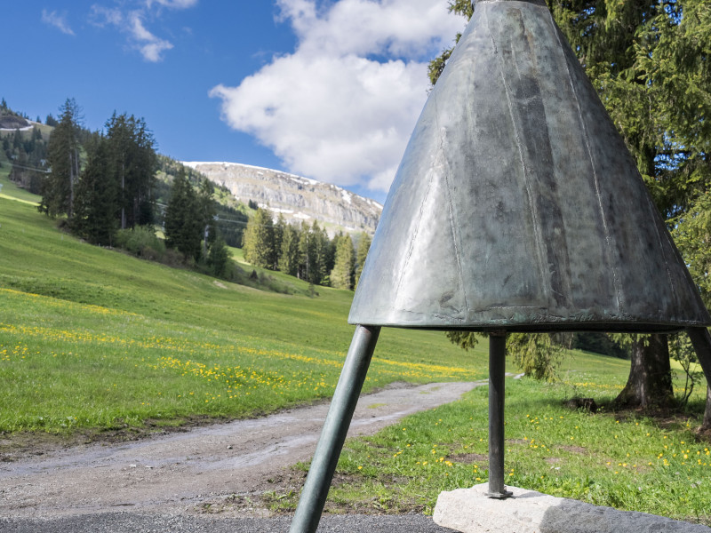 Die Klangskulptur besteht aus einem grossen, umgekehrten Metalltrichter mit zwei unterschiedlich hohen und gewichteten Antennen
